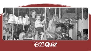 Black and white photo of two children riding King Arthur’s Carrousel at Disneyland Resort. The older girl is wearing a striped dress and waving at the camera, and the younger boy is wearing a striped shirt and dark shorts.