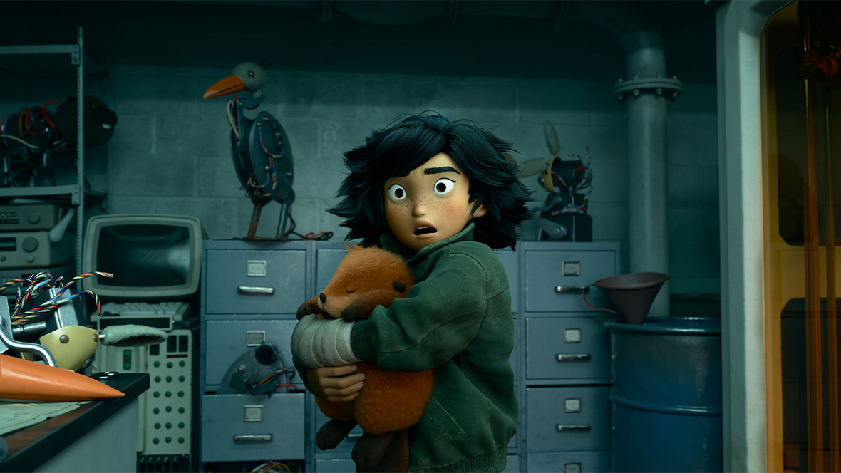 In a still from Disney and Pixar’s Hoppers, Mabel, voiced by Piper Curda, stands in profile, clutching a lifelike robotic beaver. She wears a green fleece-like jacket and has a startled expression of her face. A row of gray file cabinets, monitors, and a half-built robotic bird-like creature and rabbit are seen in the background. 