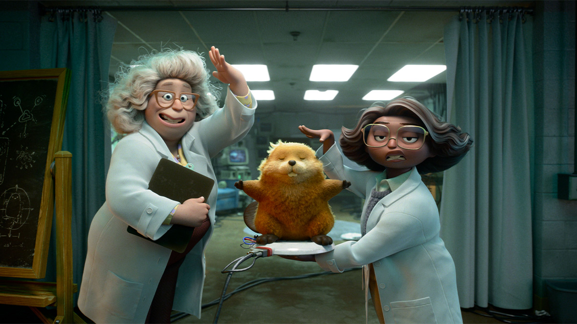 Two female scientists in lab coats and glasses stand on either side of a lab table, show off a robotic beaver, with its front paws outstretched, is displayed on a charging base at center. A chalkboard with diagrams is at left and curtains are pulled back at either side, showing a room with monitors and florescent lighting. 