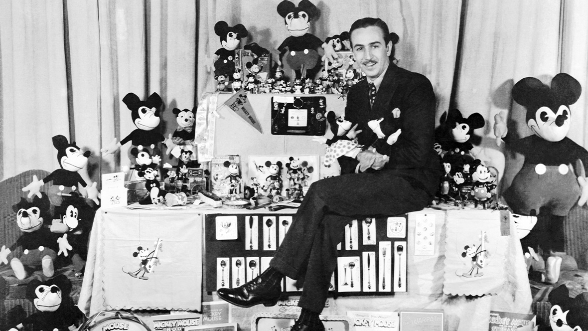 Walt Disney with various Mickey Mouse merchandise.