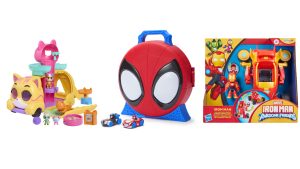 Three colorful Disney Junior preschool toys displayed side-by-side: on the left, a cat-themed playset with multiple ramps, platforms, and small animal figures; in the center, a red and blue Spider-Man face-shaped carrying case with two small toy cars; and on the right, a boxed Marvel Iron Man and His Awesome Friends set featuring an Iron Man figure and transforming vehicle.