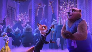 In a scene from Zootopia 2, the fox Nick Wilde, just left of center and wearing a tuxedo, holds up a necklace with a blue gem pendant in front of a smiling bear, just right of center and wearing and blue glitter outfit with a purple sash. Bunny Judy Hopps, wearing a yellow ball gown, stands to the left. Behind these three is a formal party filled with animals in fancy dress and bare trees lit with twinkle lights.