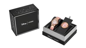 Images are shown of Citizen’s Belle, Eternal Beauty Watch Box Set: on the left, there is a black box with Disney Logo alongside a Citizen logo, both written in white. On the right, there is another Disney Citizen branded black box, this one open and showing just the bottom half, with Disney and Citizen logos in white writing. In the box is the Citizen Watch Belle, Eternal Beauty. It is rose gold with Belle on it.