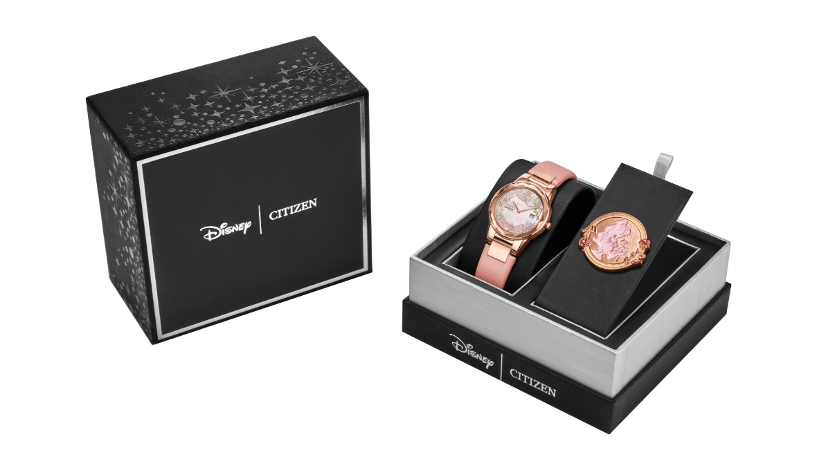 Images are shown of Citizen’s Belle, Eternal Beauty Watch Box Set: on the left, there is a black box with Disney Logo alongside a Citizen logo, both written in white. On the right, there is another Disney Citizen branded black box, this one open and showing just the bottom half, with Disney and Citizen logos in white writing. In the box is the Citizen Watch Belle, Eternal Beauty. It is rose gold with Belle on it.