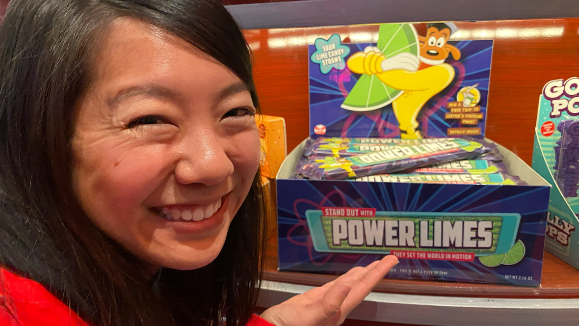 Allie Wong, a creator of the Power Limes candy seen in the attraction queue for Mickey & Minnie’s Runaway Railway in Disneyland Park, posing with the candy and smiling.