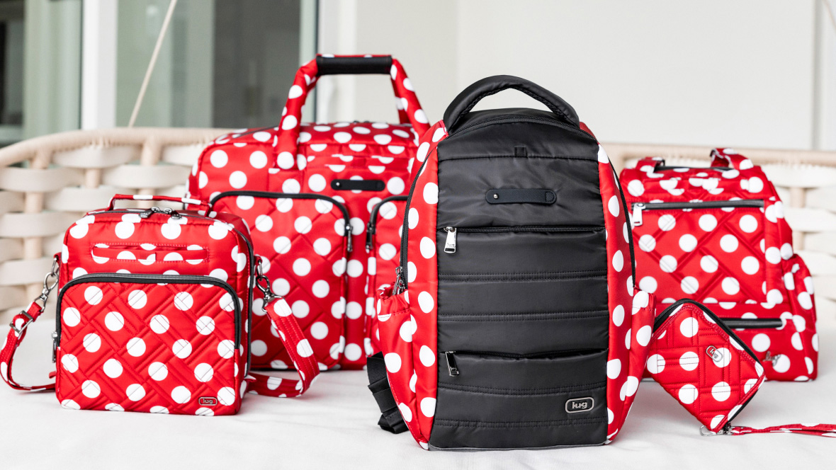 A Lug promotional image of red backpacks with white dots, similar to Minnie Mouse’s signature outfit, branded with the Lug logo displayed on a white tabletop.