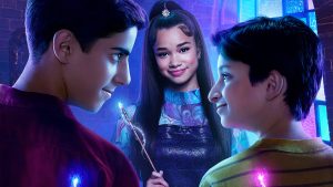 In a key art image from Disney’s Wizards Beyond Waverly Place, Roman (played by Alkaio Thiele) and Milo (played by Max Matenko) are seen in the foreground—looking at each other as they each hold wands behind their backs. In between them and slightly toward the background is Billie (Janice LeAnn Brown), who is holding her own wand and smiling at the camera.