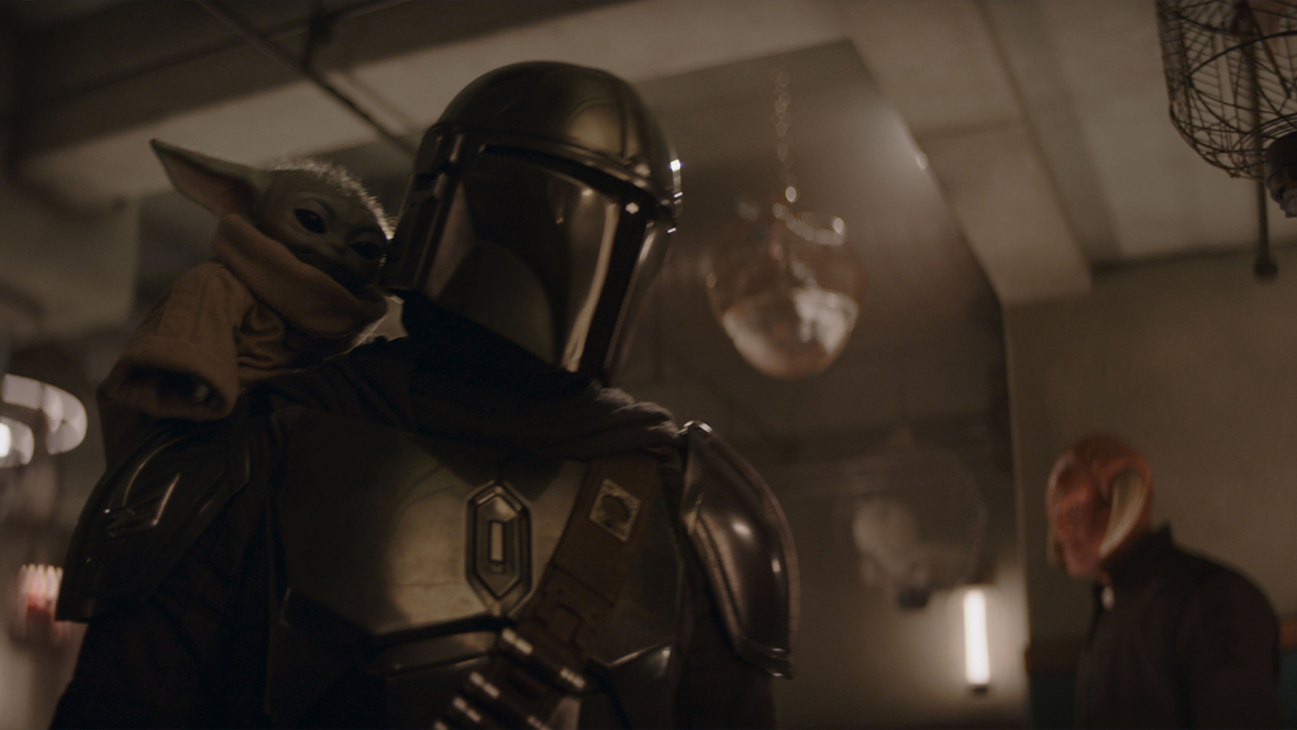 In an image from Lucasfilm's Star Wars: The Mandalorian and Grogu, Din Djarin (Pedro Pascal) and Grogu are standing together, whereabouts unknown.