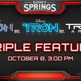 Red glowing light borders a black backdrop, with the logo “Disney Springs” in the top center. In the middle are three logos for the movies “TRON”, “TRON: Legacy”, and “TRON: Ares”. Below in glowing red text reads “Triple Feature October 8 3:00 PM.”