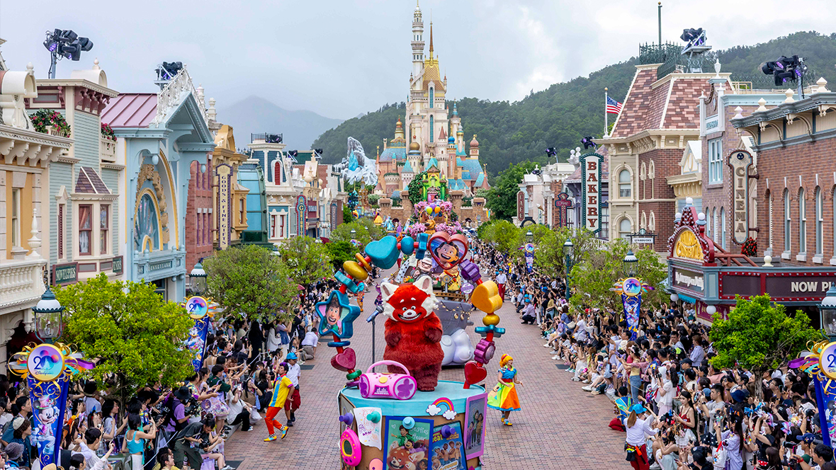 The Friendtastic parade during “The Most Magical Party of All” celebrating Hong Kong Disneyland’s 20th anniversary. Mei from Turning Red can be seen on a float in the foreground, and hundreds of guests line the route.