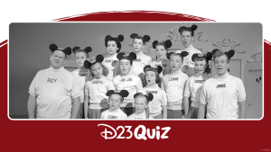 In this black-and-white photo, 12 members of the original Mickey Mouse Club TV series are at center, dressed in white turtleneck sweaters with their first names visible and mouse ear hats. Disney Legend Jimmie Dodd, who played the lead grown-up Mouseketeer and moral compass, stands at far right, with fellow adult leader (and Disney Legend) Roy Williams.