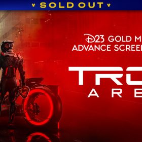 A background of a sepia tone city landscape on the left-hand side of the image. In the foreground is a red Lightcycle with a driver in a black light suit standing in front of it. The right side of the image is washed in the same red as the Lightcycle, and in white text reads: “D23 Gold Member Advance Screenings of TRON: Ares.” A banner at the top reads "SOLD OUT."