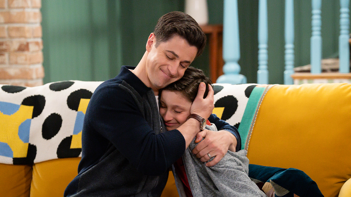 Justin Russo (played by David Henrie) hugging his son, Milo (played by Max Matenko) on Wizards Beyond Waverly Place.