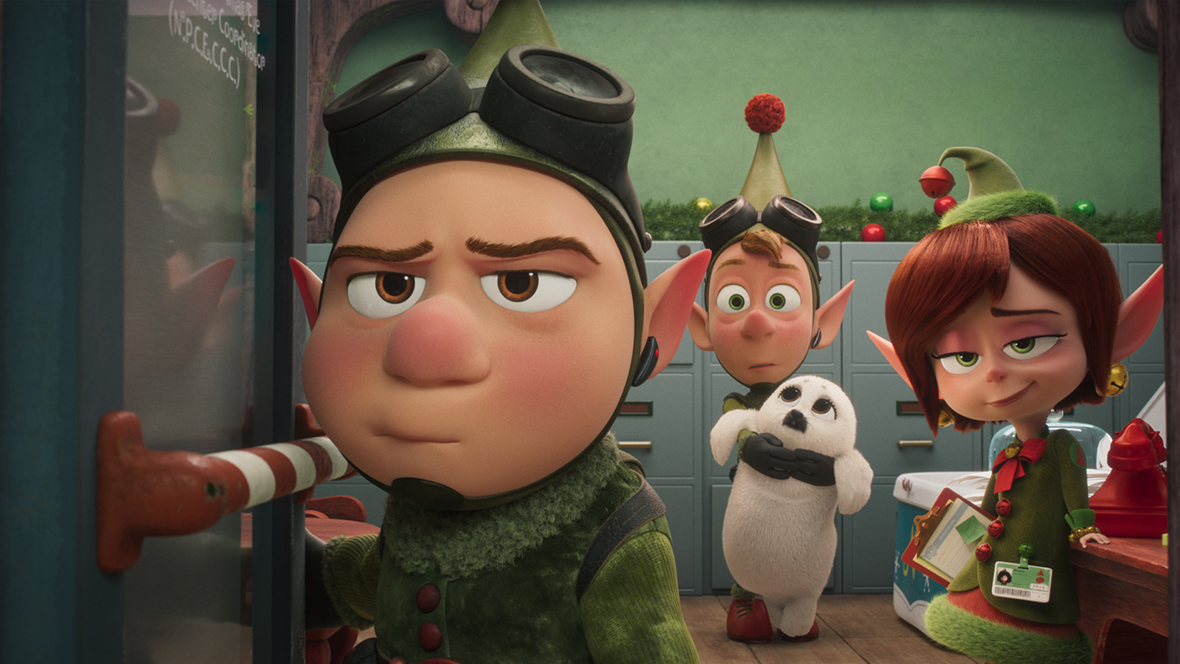 Wayne (voiced by Dave Foley), Lanny (voiced by Derek Richardson), and Magee (voiced by Sarah Chalke) in a still from Prep & Landing: The Snowball Protocol. The elves all appear in an office at the North Pole, and Lanny is holding a white baby seal.