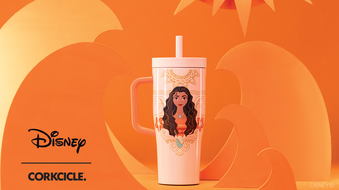 A light pink Corkcicle cup sits in front of a dark yellow background surrounded by light orange shapes representing ocean waves and a sun. The cup itself sports a line drawn illustration of Moana from the chest-up. She’s surrounded by line art shapes representing waves and a sun. Two hibiscus flowers sit on either side of the princess, framing her within the design. The cup has a screw-on lid and a straw protruding from the top. Its handle is sturdy and an orange color. To the left of the graphic are the Disney and Corkcicle logos, separated by a thin black line.