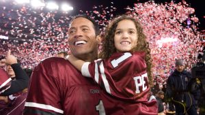 (From left to right) Joe Kingman (played by Dwayne &ldquo;The Rock&rdquo; Johnson) holding Peyton Kelly (played by Madison Pettis) in a still from The Game Plan.