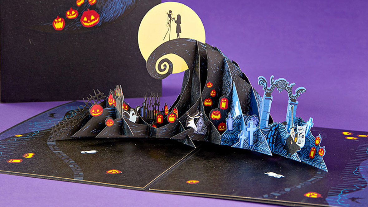 A pop-up greeting card features Jack Skellington and Sally from Tim Burton’s The Nightmare Before Christmas on a hill in front of a full moon.