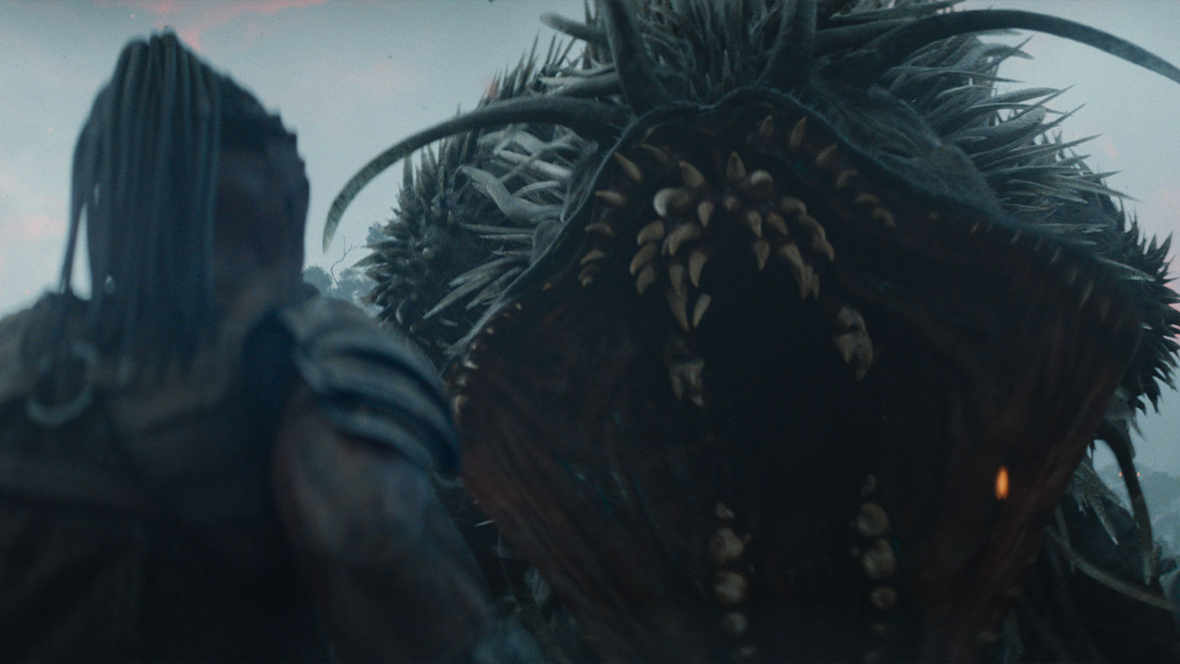 The Predator Dek, played by Dimitrius Schuster-Koloamatangi, faces the Kalisk, an unkillable creature, in a scene from 20th Century Studios' Predator: Badlands.