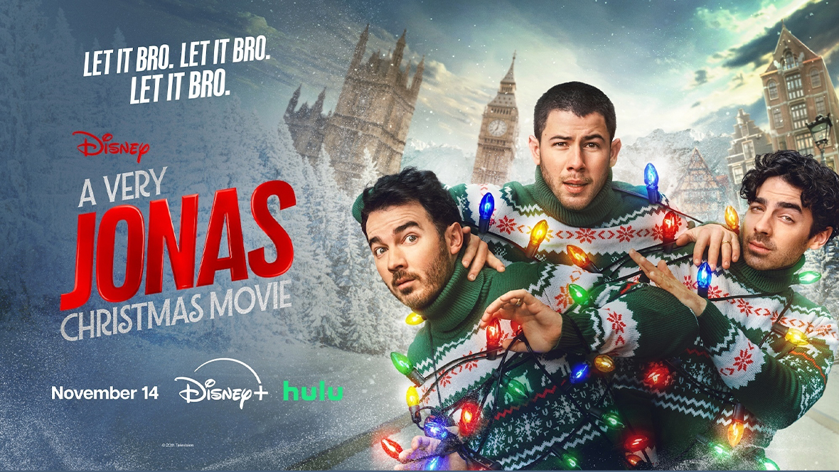 Key art for A Very Jonas Christmas Movie features the logo for the movie, the November 14 premiere date on Disney+, and from left to right, Kevin Jonas, Nick Jonas, and Joe Jonas in red, green, and white holiday sweaters, tangled up in colorful Christmas lights.