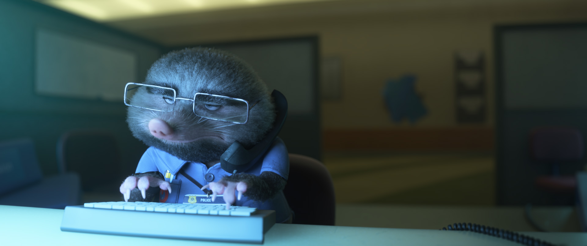Ornery mole and ZPD IT expert Paul Moledebrandt grimaces as he talks on the phone while typing away on his computer. He is sitting in a dimly lit and deserted office.
