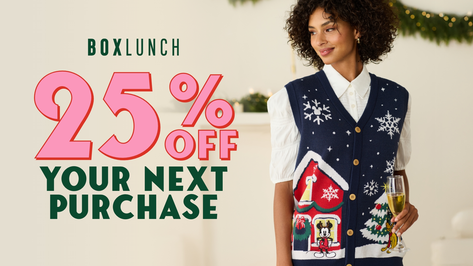 A woman stands in a room decorated for Christmas. She wears a dark blue vest featuring Mickey Mouse in a red Christmas-themed house, surrounded by white snowflakes and stars. She holds a glass of champagne. The left side of the graphic reads: “BoxLunch 25% off your next purchase.”
