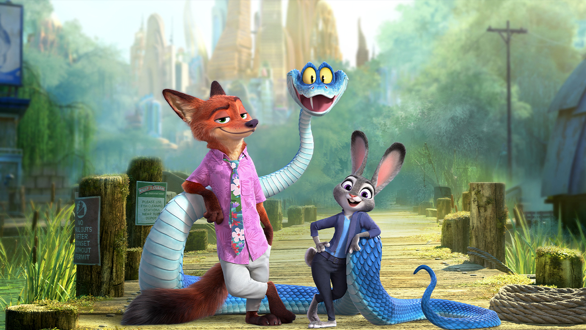 In a promotional still from Walt Disney Animation Studios’ Zootopia 2, from left to right, Nick Wilde (voiced by Jason Bateman), Gary De’Snake (voiced by Ke Huy Quan), and Judy Hopps (voiced by Ginnifer Goodwin) are seen standing on a dock and smiling at the camera. Both Nick and Judy are leaning on parts of Gary’s body.