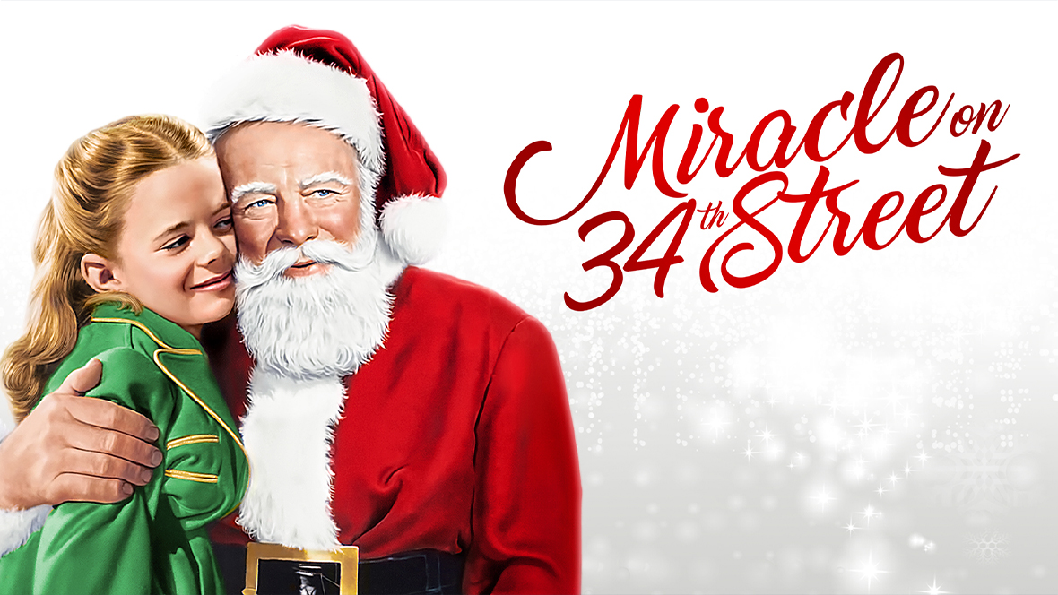 Kris Kringle (played by Edmund Gween) hugging Susan Walker (played by Natalie Wood) in Miracle on 34th Street.
