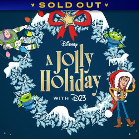A promotional image for the "A Jolly Holiday with D23" event in December 2025. Featured is a Toy Story, snow-covered wreath graphic— on the left, Buzz Lightyear climbs along a string of Christmas lights, and on the right, Woody poses while donning an oversized Santa hat. Also included are the Pizza Planet aliens, and a large red bow with a star evoking a sheriffs badge. The characters are hosted on a dark navy background with gold stars along the sides. A banner at the top reads SOLD OUT.