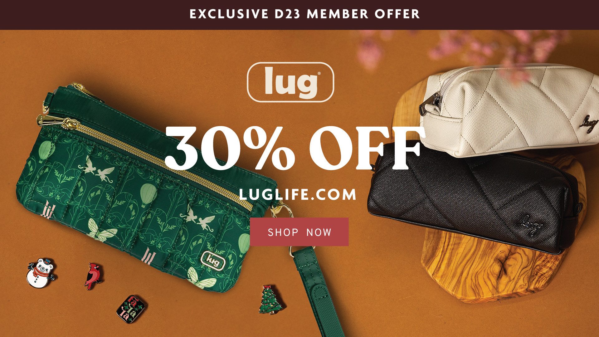 An image of three lug pouches (one green, one white, and one black) sit scattered on a brown table, with charms set below them. The copy on the graphic reads “Exclusive D23 Member Offer. 30% off. LugLife.com. Shop Now.”