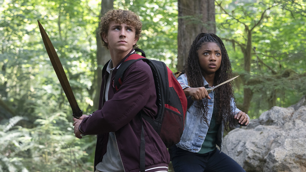 Percy Jackson, played by Walker Scobell, wields a sword, while Annabeth Chase, played by Leah Sava Jeffries, wields a dagger, in Disney's Percy Jackson and the Olympians.