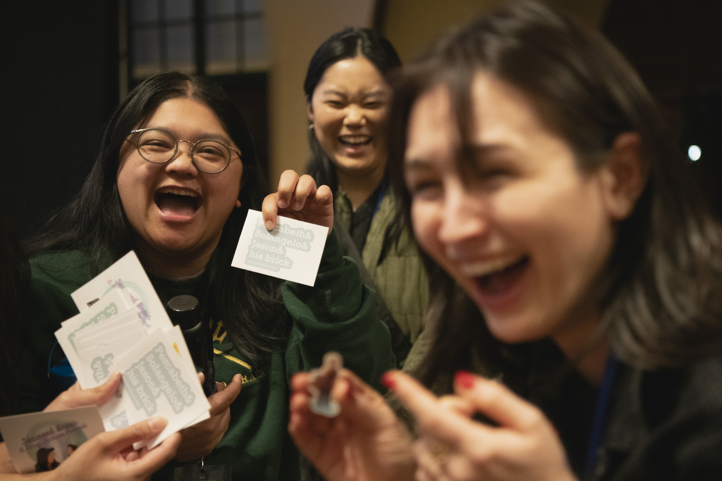 A group of fans exchange hand-made giveaways at D23&rsquo;s Percy Jackson and the Olympians Spotlight Series event in Glendale, CA. Some stickers are figures of Percy Jackson characters, while others feature text of popular &ldquo;ship&rdquo; names from the series, one of which is held and shown off to the camera with a big smile.