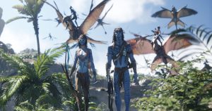 In an image from 20th Century Studios&rsquo; Avatar: Fire and Ash, Neytiri (Zoe Salda&ntilde;a), left, and Jake Sully (Sam Worthington), right, are walking through a jungle scene as other warriors on flying creatures swirl around them in the sky.