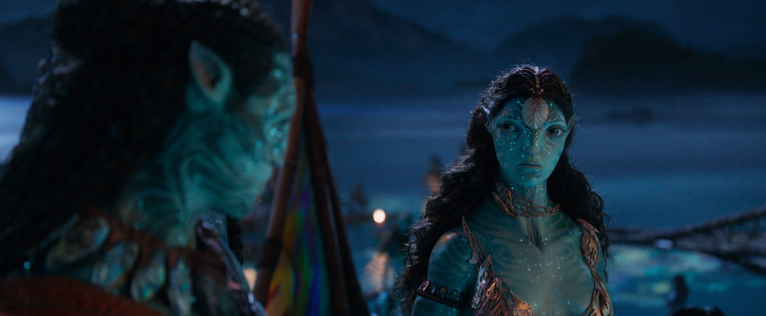 In an image from 20th Century Studios&rsquo; Avatar: Fire and Ash, Tonowari (Cliff Curtis), left, and Ronal (Kate Winslet), right, are looking intently at each other; Tonowari&rsquo;s back is mostly to the camera. It is nighttime.