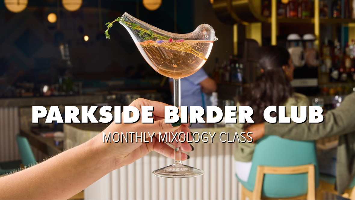 A hand holds up a stemmed wine glass shaped like a bird, with an opening in the &ldquo;tail&rdquo; for sipping. The background showcases the busy Vista Parkside Market venue; tables are filled with people. White text reading &ldquo;PARKSIDE BIRDER CLUB, MONTHLY MIXOLOGY CLASS&rdquo; sits at the middle of the image.
