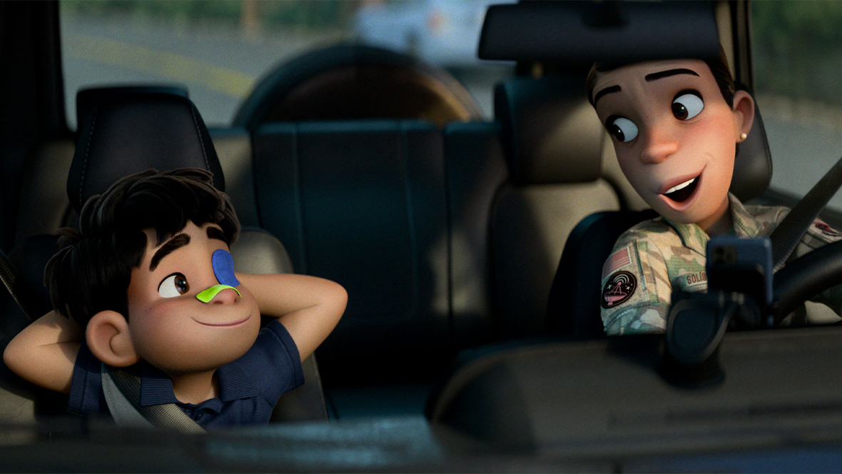 Elio, a young boy with dark hair and a blue eye patch, sits in the passenger seat with his hands behind his head and a smile on his face. Aunt Olga, wearing a military-style camouflage jacket with a special patch on the shoulder, smiles at him from the driver's seat.