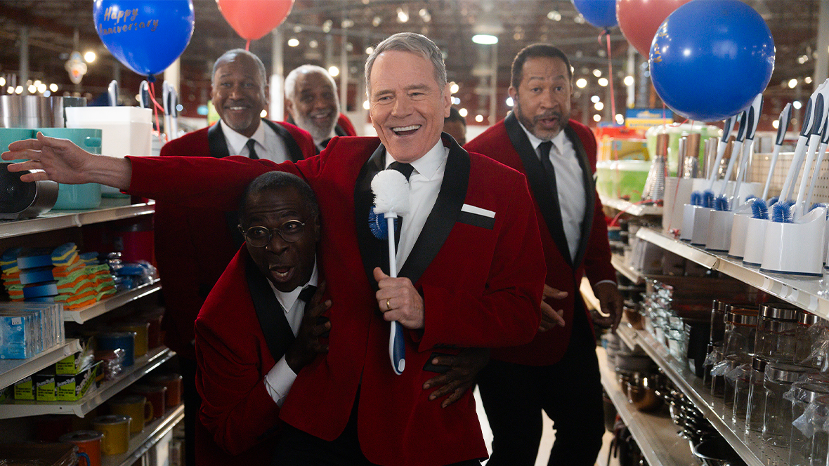 From left to right, Malcolm in the Middle: Life's Still Unfair stars Jonathan Craig Williams, Alex Morris, Gary Anthony Williams, Bryan Cranston, and John Marshall Jones wear red velvet jackets and black dress pants as they sing a musical number inside a store.