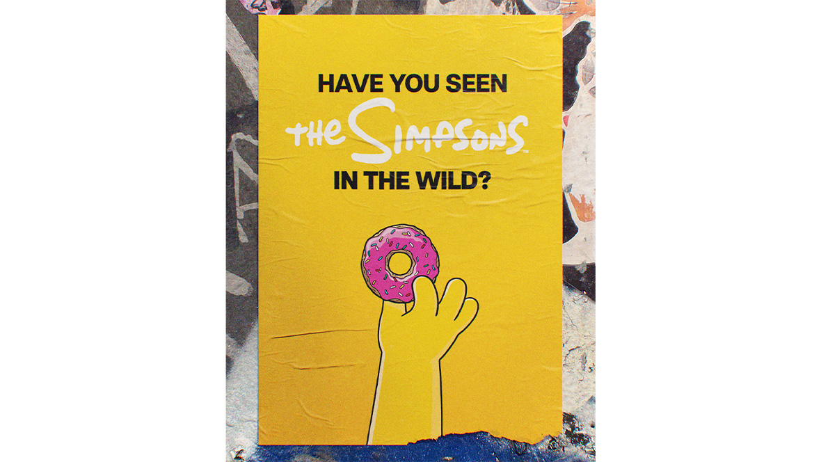 An image from The Simpsons’ current social media campaign #SimpsonsInTheWild; it features Homer’s hand holding up a pink donut with sprinkles, with the phrase “Have you seen The Simpsons in the wild?” above it.