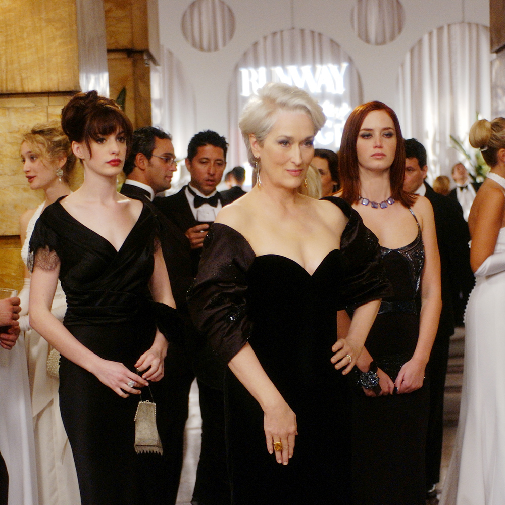 Disney Legend Anne Hathaway as Andy, Meryl Streep as Miranda Priestly, and Emily Blunt as Emily, all wearing black party dressed.