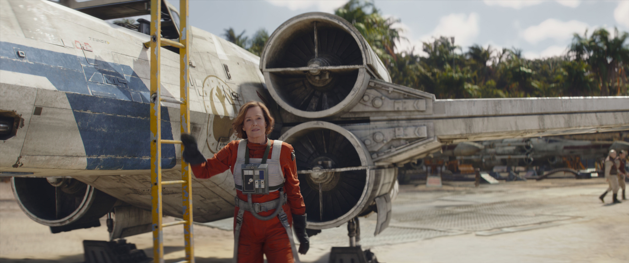 An image from Lucasfilm&rsquo;s Star Wars: The Mandalorian and Grogu featuring Sigourney Weaver as Colonel Ward. She is next to a ladder that leads to the cockpit of an X-Wing, and is wearing an X-Wing pilot&rsquo;s uniform.