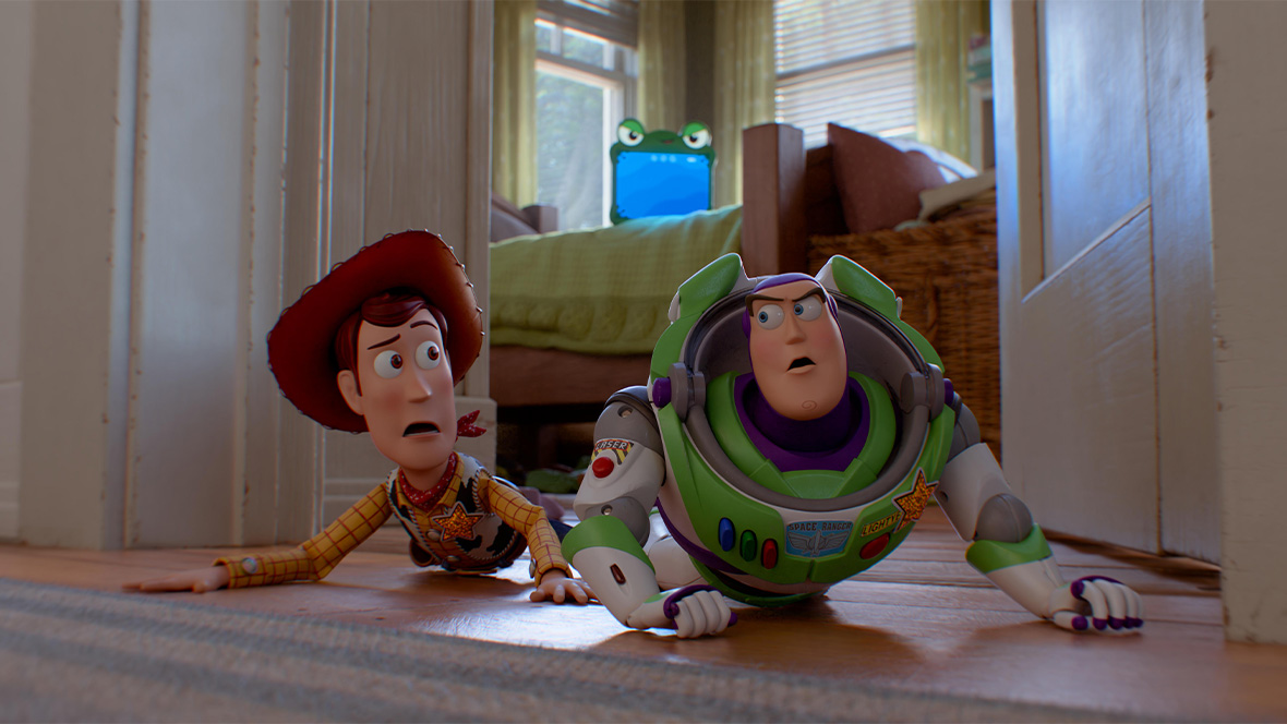 n an image from Disney and Pixar&rsquo;s Toy Story 5, Woody (voiced by Tom Hanks), left, and Buzz Lightyear (voiced by Disney Legend Tim Allen), right, are laying on their stomachs on the floor and looking quizzically at each other. Lilypad (voiced by Greta Lee) can be seen sitting on the bed behind them.