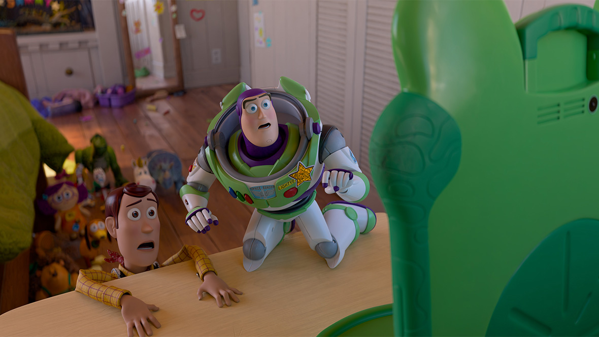 In an image from Disney and Pixar&rsquo;s Toy Story 5, Woody (voiced by Tom Hanks), left, and Buzz Lightyear (Disney Legend Tim Allen), right, are on the edge of a bedroom dresser and staring at tablet device Lilypad (voiced by Greta Lee). Other toys can be seen on the floor in the background. 