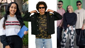 Models display Walt Disney Imagineering apparel and accessories, including a branded sweatshirt, graphic shirt, tote bag, and patterned pants.