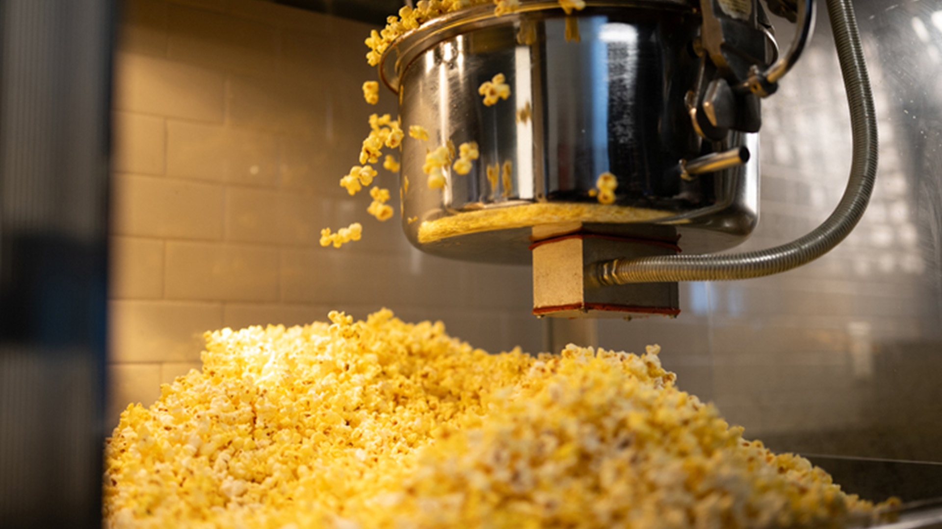 A popcorn machine with fresh popcorn being made.