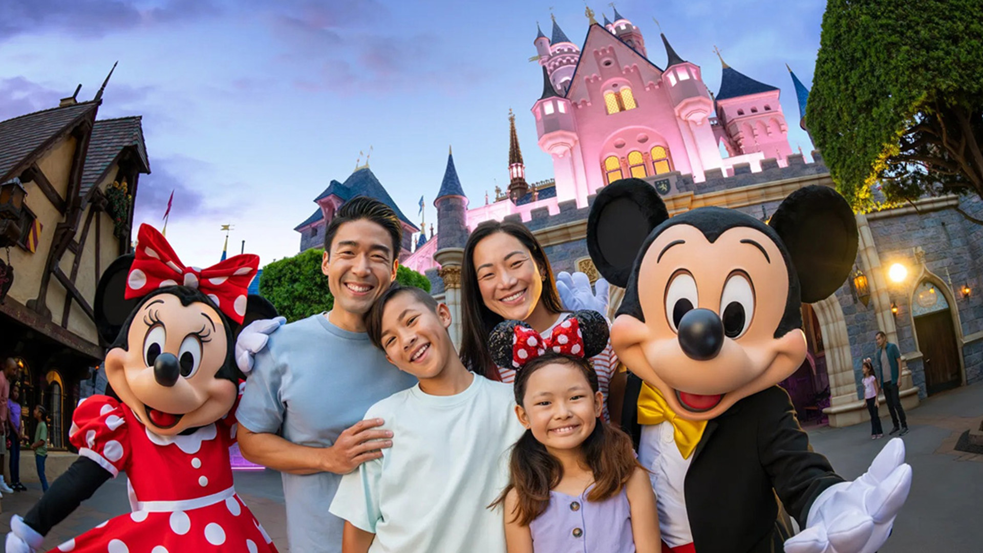 A family posing with Mickey and Minnie Mouse