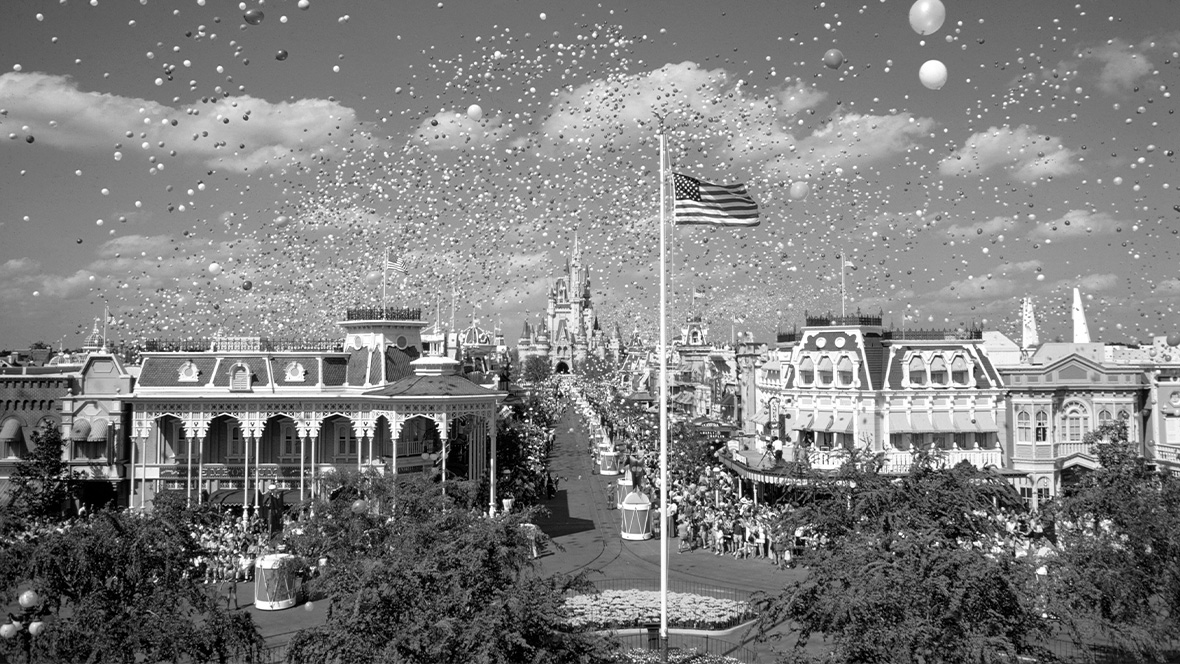 An image of the flag being flown over Town Square on Main Street, U.S.A. during the grand dedication ceremony of Magic Kingdom at Walt Disney World on October 25, 1971, courtesy Walt Disney Archives.