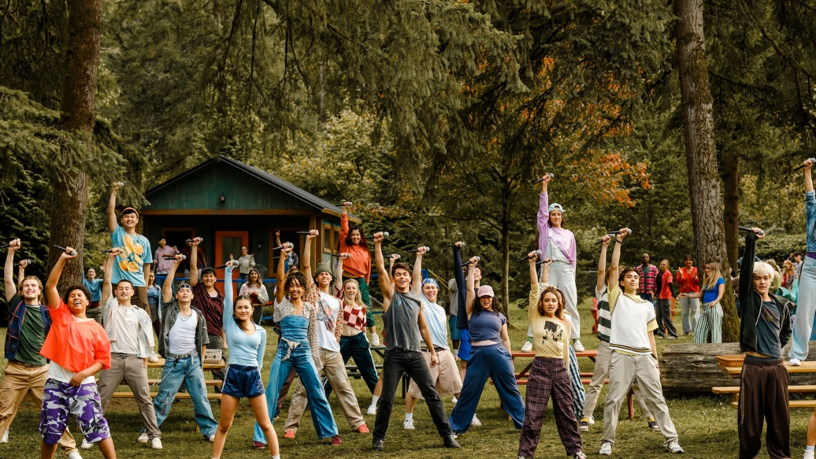 Campers perform "One Beat Away" near a cabin in a scene from Camp Rock 3.