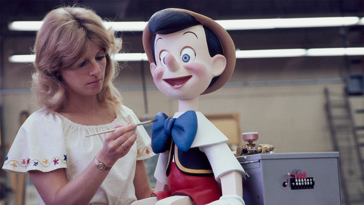 Disney Legend Kim Irvine touches up a Pinocchio figurine.