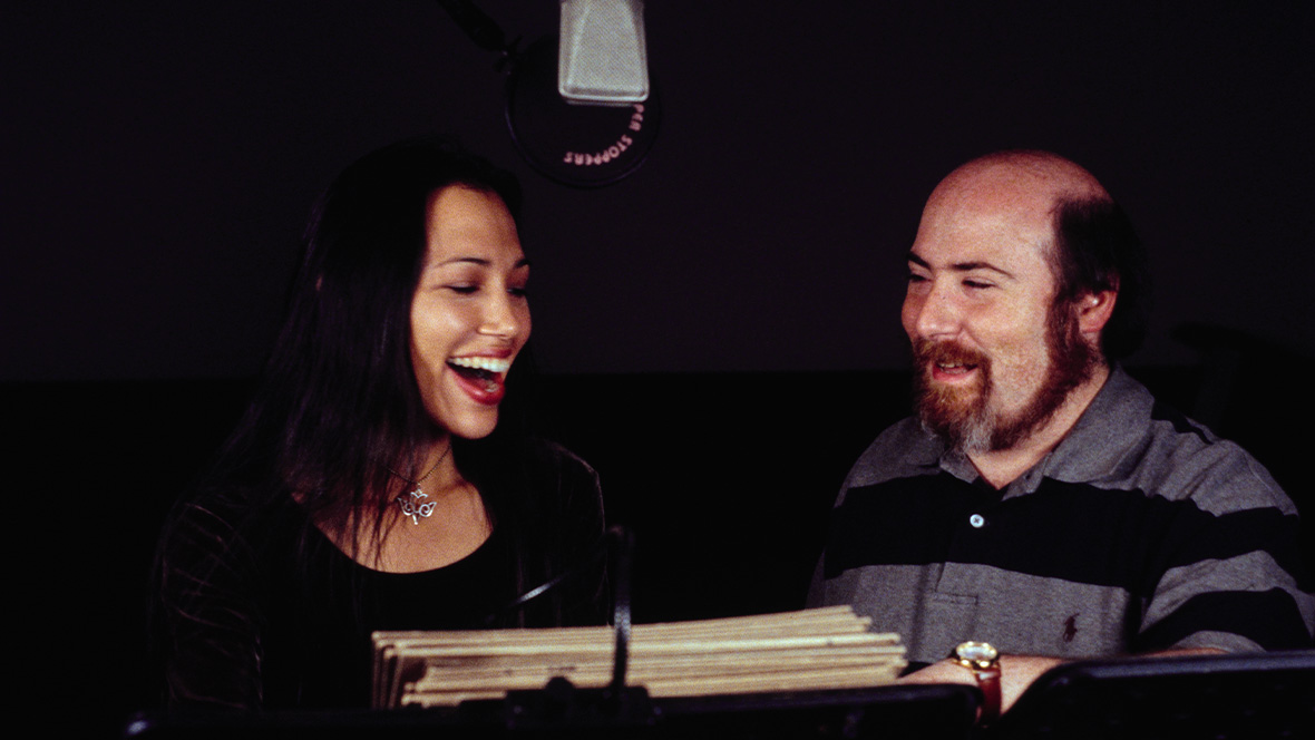 Disney Legend Eric Goldberg stands in a recording booth with Irene Bedard.