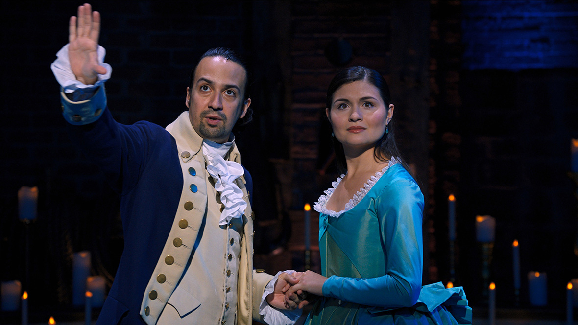 Alexander Hamilton, played by Disney Legend Lin-Manuel Miranda, and Eliza Schuyler, played by Phillipa Soo, appear onstage in the filmed version of Hamilton on Broadway.