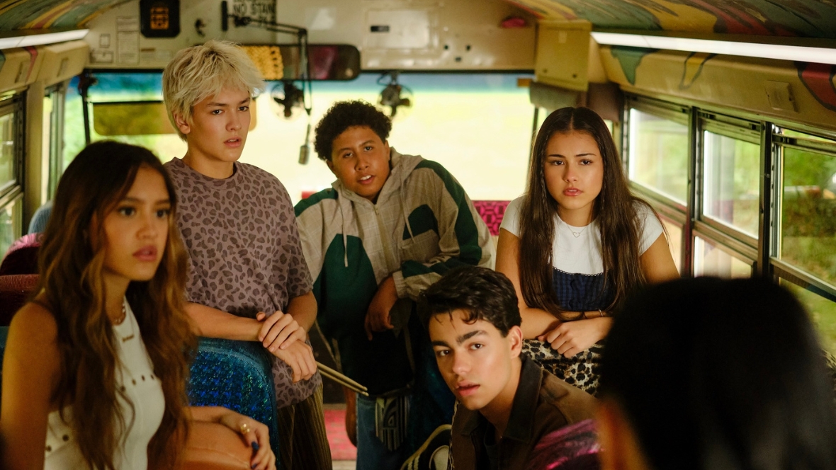 Sage, played by Liamani Segura, Desi, played by Hudson Stone, Cliff, played by Casey Trotter, Fletch, played by Malachi Barton, and Callie, played by Brooklynn Pitts, sit inside a school bus and listen to Lark, played by Sherry Cola, in a scene from Camp Rock 3.